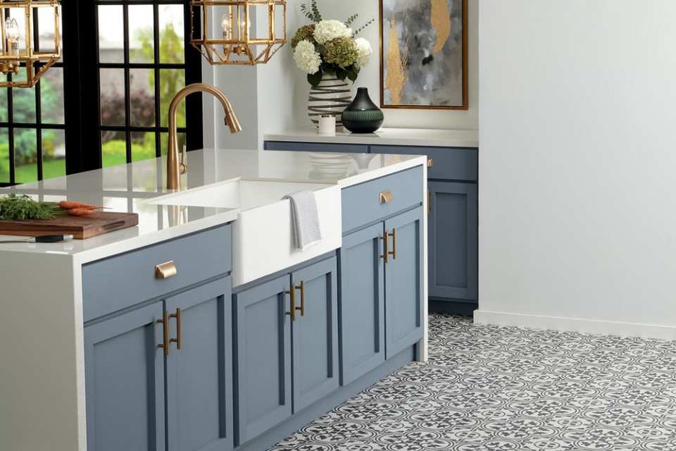 floral black patterned floor tile in modern blue kitchen with gold metal accents